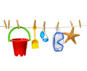 Child's summer toys on clothesline against white background